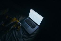 Laptop lit up in dark room