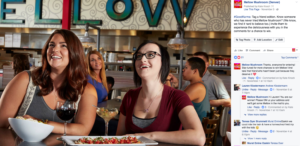 Women smiling with pizza and drinks